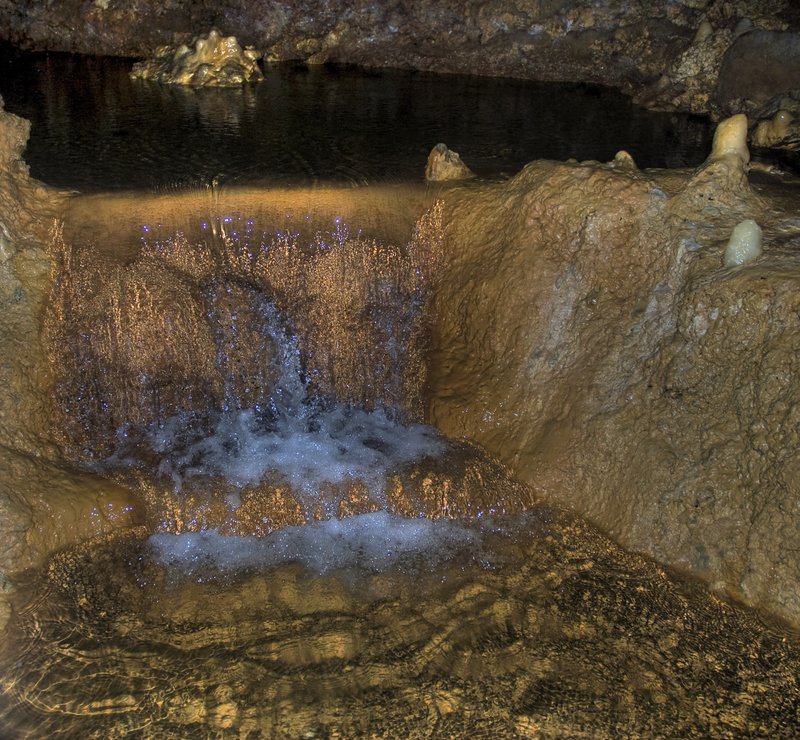Harrison's Cave — golden-lit cavern pool with stalactites, Barbados
