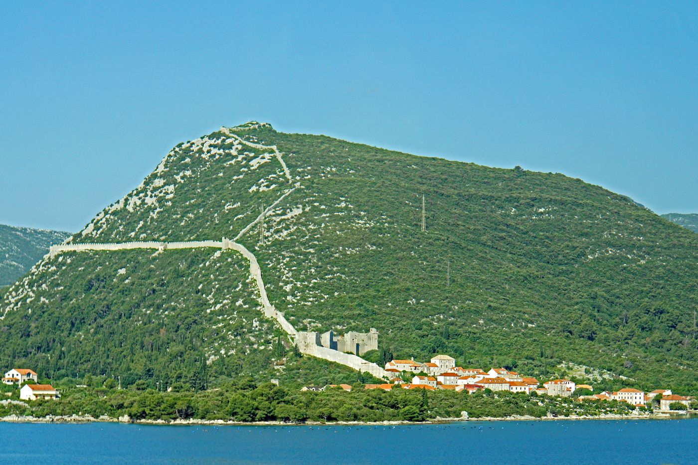 Walls of Ston stretching across the ridgeline above the salt pans
