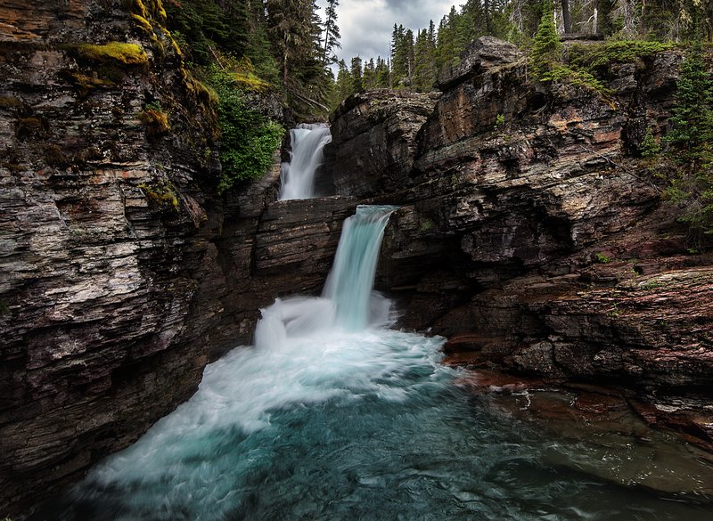 St. Mary Falls with turquoise glacial meltwater pooling at the base of the tiered drop