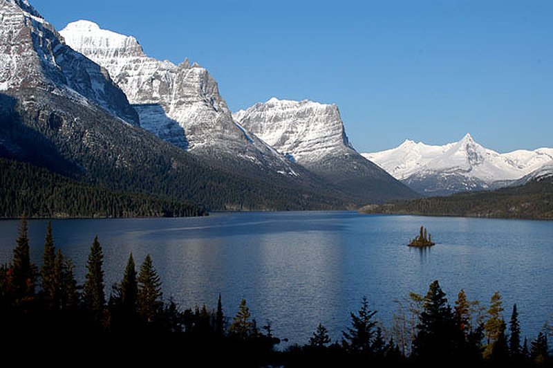 Wild Goose Island as a small forested speck in St. Mary Lake with mountain peaks behind