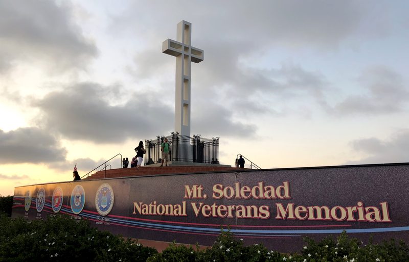 Mount Soledad National Veterans Memorial with cross and curved granite walls at dusk