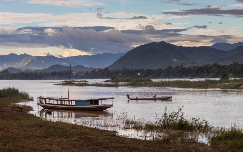 Pirogue and boat on the Mekong River at sunset in Luang Prabang
