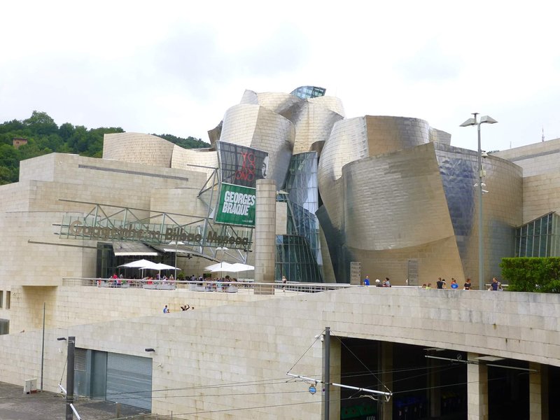 Titanium-clad curving volumes of the Guggenheim Museum Bilbao on the Nervión riverfront
