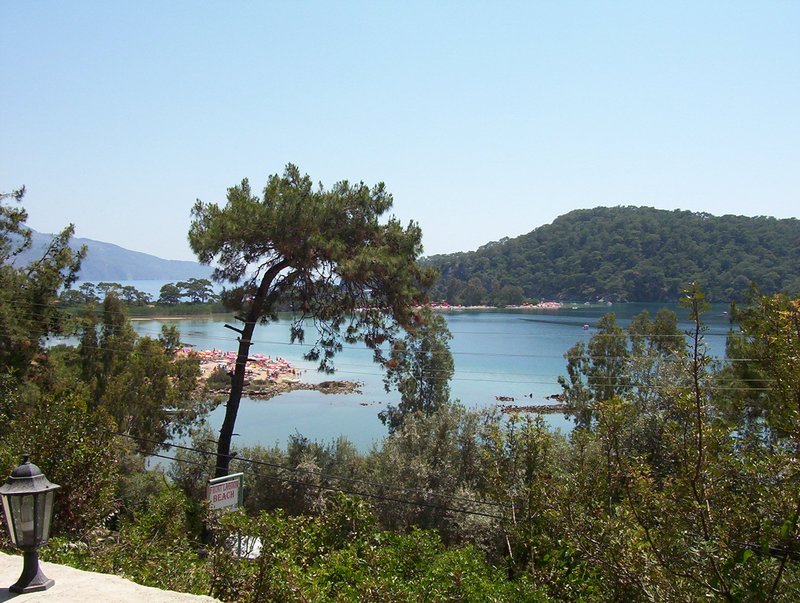Sandbar-enclosed blue-green lagoon beneath pine-covered mountains at Ölüdeniz, Turkey