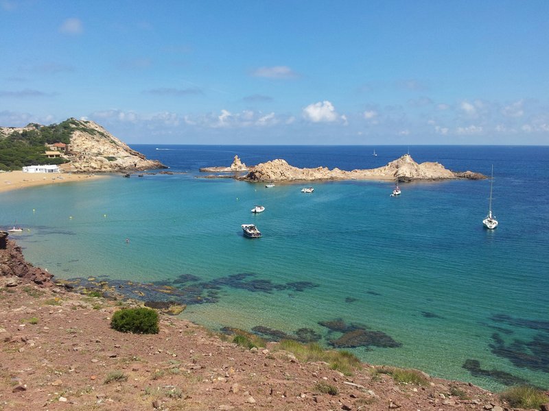 Cala Pregonda's reddish sand cove and rock islet, Menorca