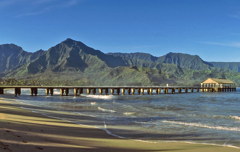 Hanalei Bay and pier on Kauai's north shore backed by green mountain ridges