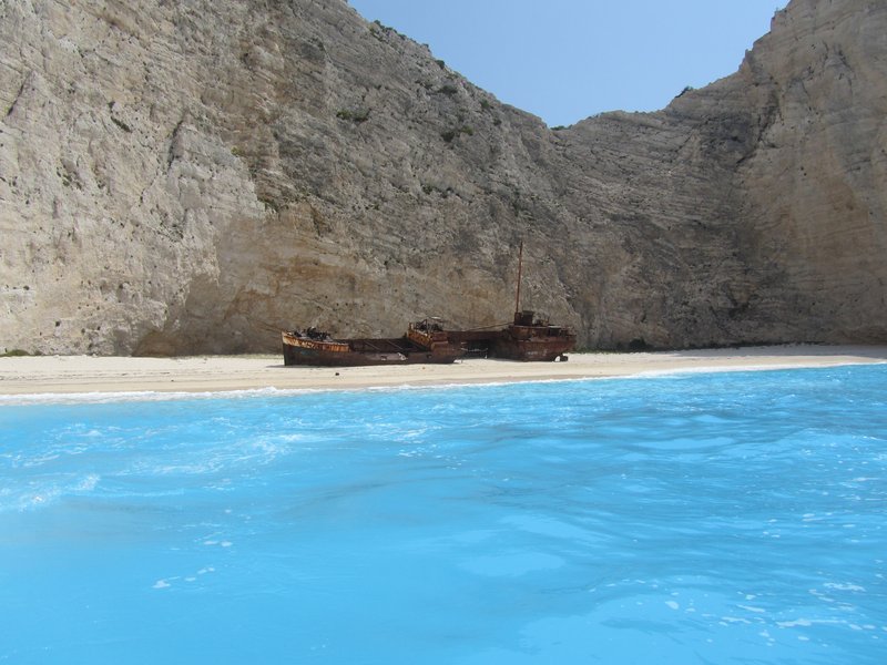 Aerial view of Navagio Beach's white sand cove, shipwreck, and limestone cliffs, Zakynthos
