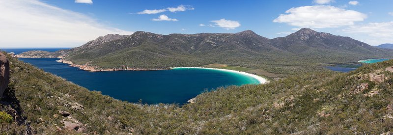 Curved white-sand Wineglass Bay seen from the granite saddle lookout, Freycinet National Park