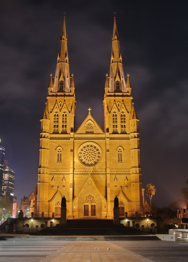 St. Mary's Cathedral illuminated at night, its twin Gothic spires lit gold