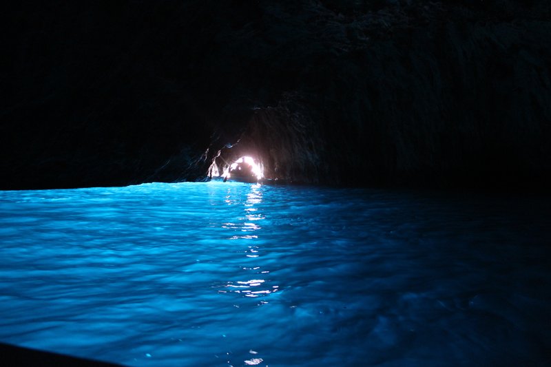 Glowing blue water inside the sea cave entrance of the Blue Grotto on Capri