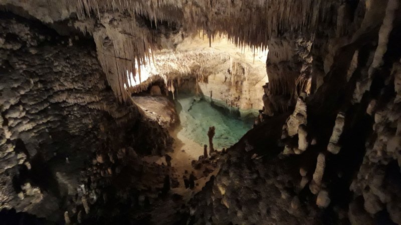 Lake Martel's turquoise water beneath stalactite formations inside the Drach Caves, Mallorca