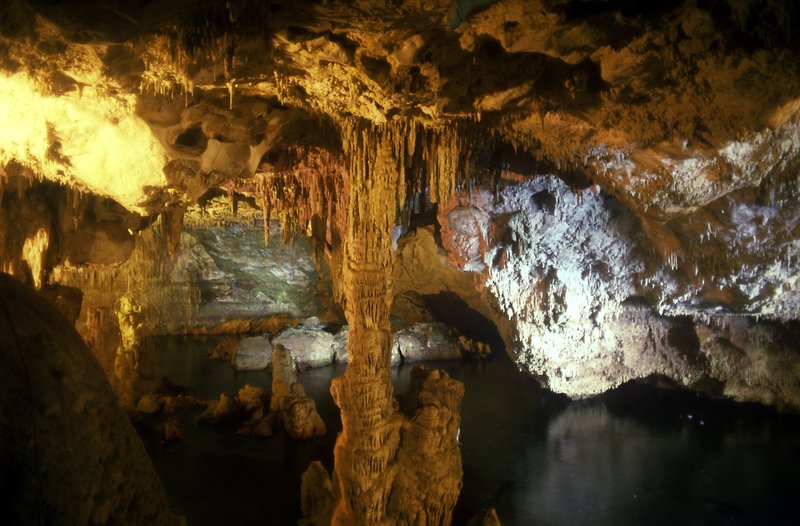 Underground saltwater lake reflecting stalactites and stalagmites inside Grotta di Nettuno