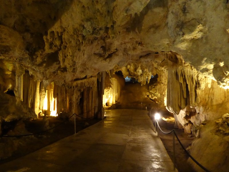 Lit walkway through a large stalactite-lined hall inside the Nerja Caves, Spain