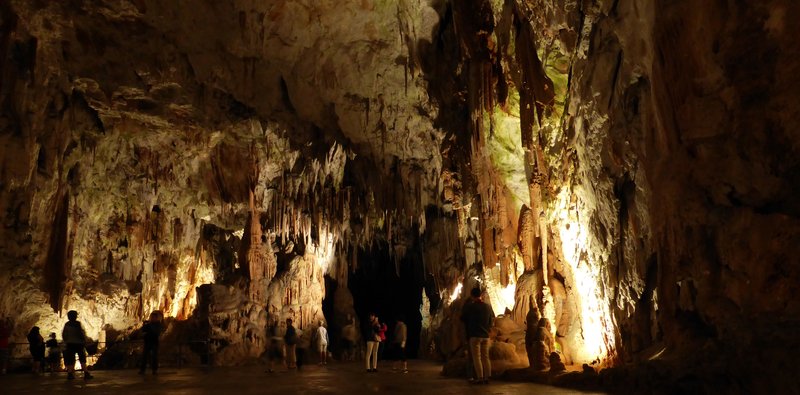 Visitors touring a large limestone chamber inside Postojna Cave, Slovenia