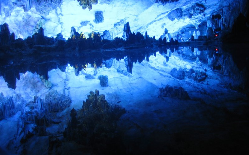 Illuminated underground lake inside Reed Flute Cave