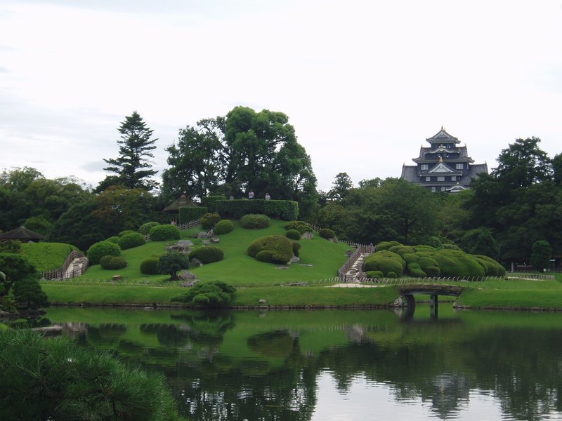 Korakuen garden lawns and pond with Okayama Castle across the river