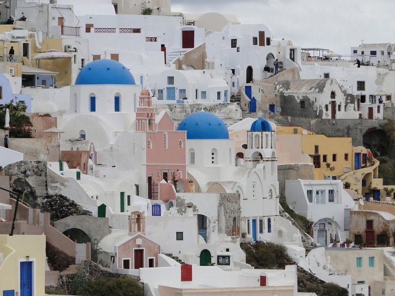 Blue-domed churches and whitewashed buildings cascading down the cliffside in Oia, Santorini