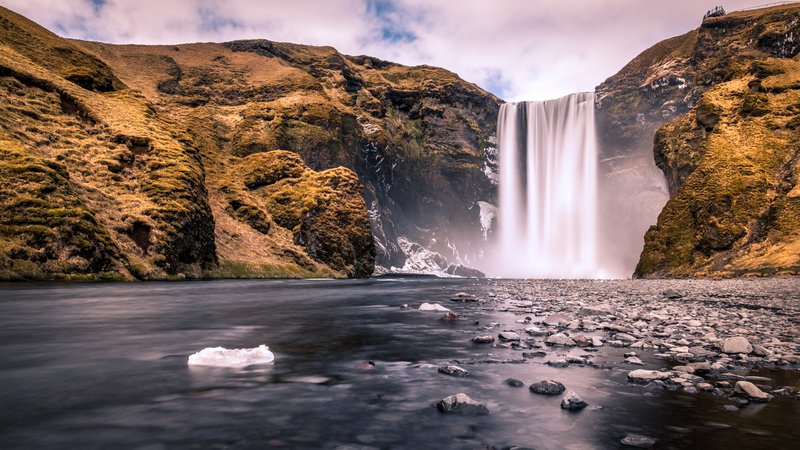 Skógafoss waterfall dropping over a mossy cliff face in southern Iceland