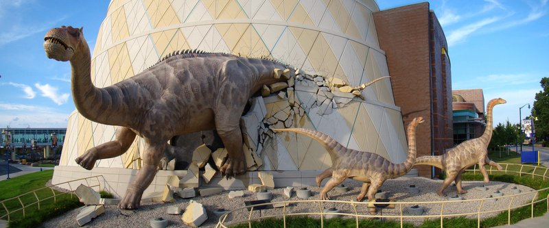 Dinosaur sculptures bursting through the Dinosphere dome at The Children's Museum of Indianapolis