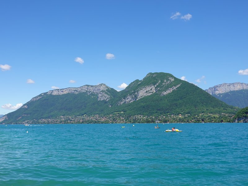 Clear alpine waters of Lake Annecy with the Savoy mountains behind
