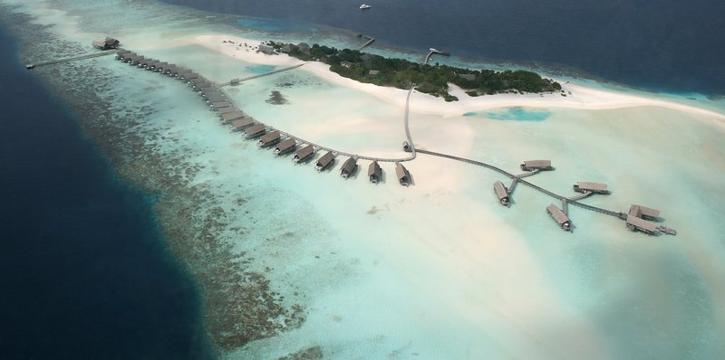 Aerial view of coral reef formations surrounding a Maldives island, Indian Ocean