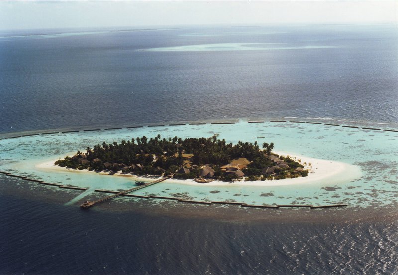 Overwater villas extending into a turquoise Maldives lagoon