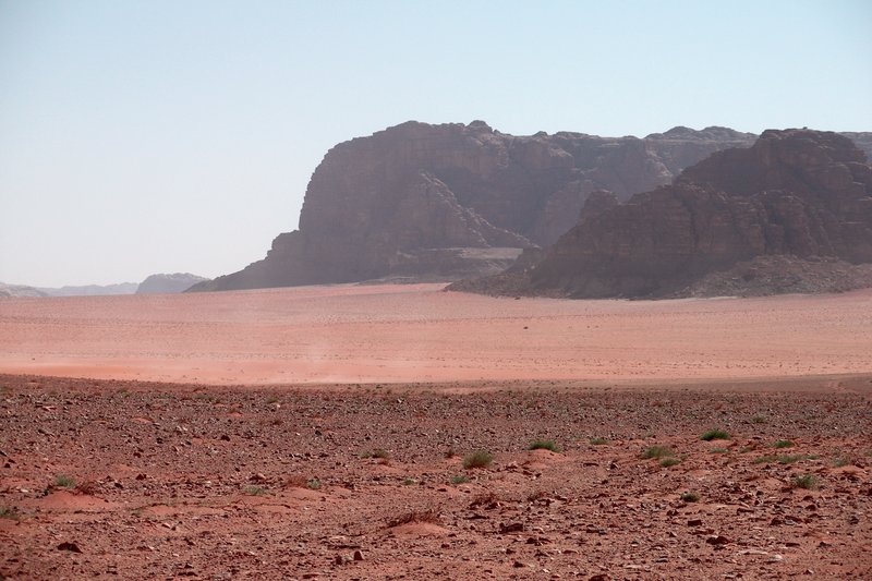 Sandstone mountains and cliffs rising from the Wadi Rum desert floor