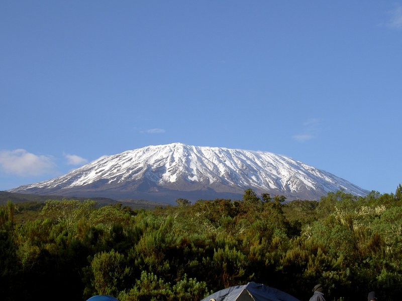 Snow-capped summit of Mount Kilimanjaro rising above the surrounding plains