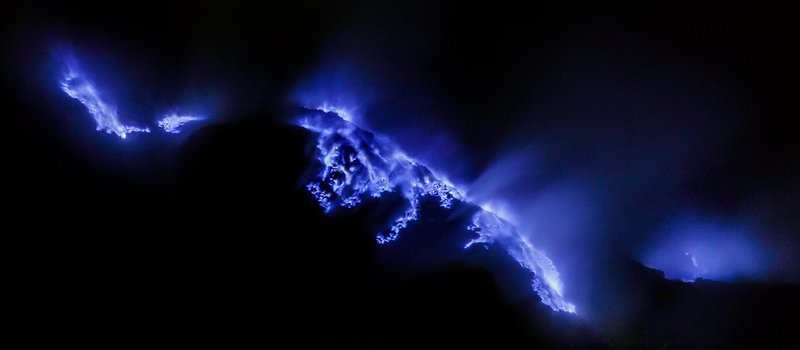 Blue sulphuric flames glowing at the Kawah Ijen crater at night