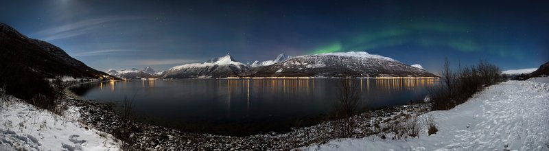 Aurora borealis over the fjords and snow-covered Lyngen Alps near Tromsø