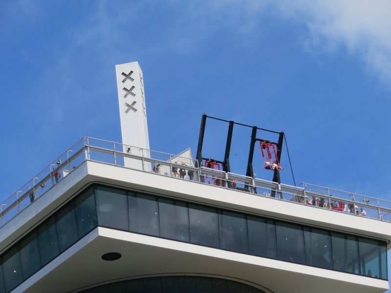 A'DAM Toren's rooftop swing hanging over the edge above Amsterdam