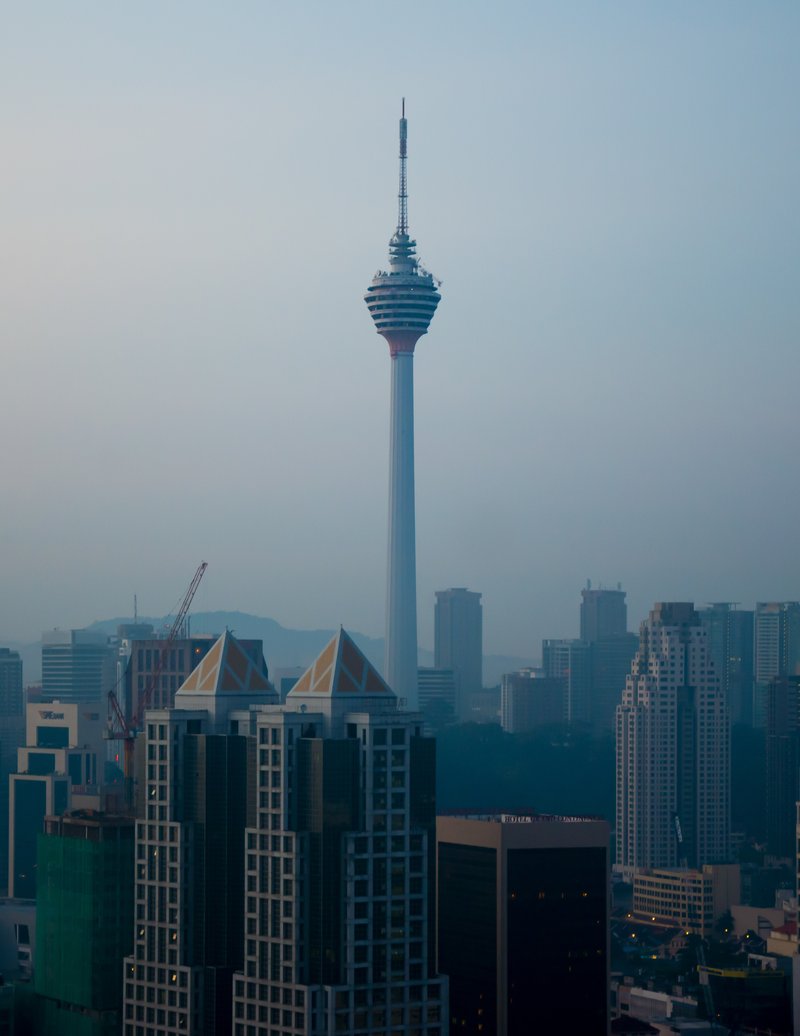 Kuala Lumpur Tower rising above the city skyline at dusk