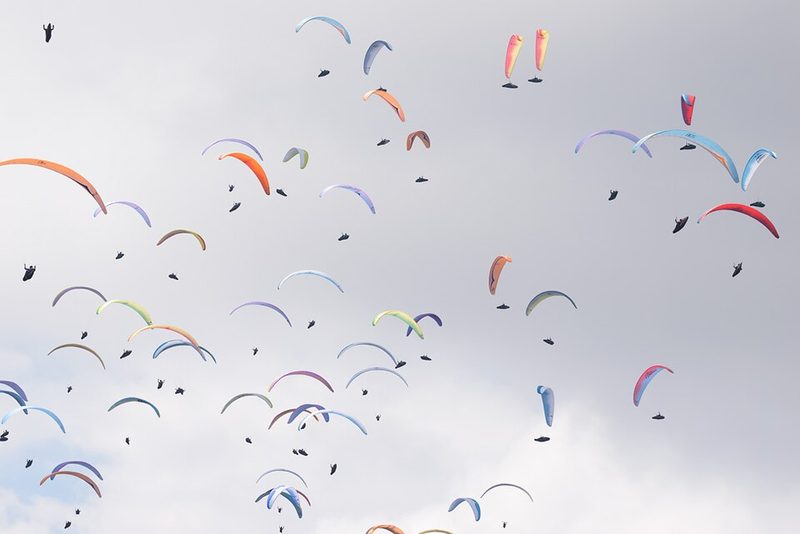 Paragliders in the air above Monte Grappa during a competition