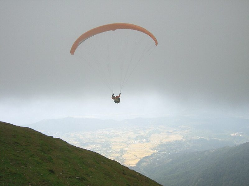 Paraglider launching from Billing above the Dhauladhar range, Himachal Pradesh