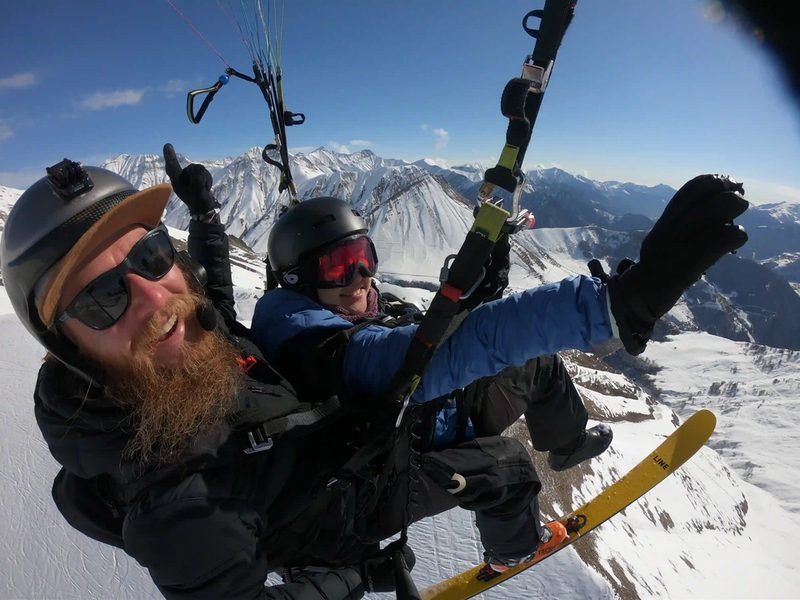 Tandem paraglider flying above the snow of Gudauri in the Greater Caucasus