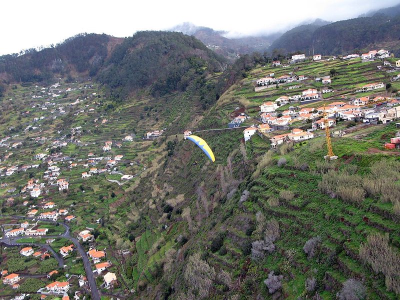 Paraglider above the terraced slopes at Arco da Calheta, Madeira