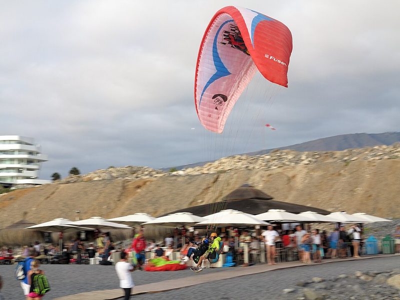 Tandem paraglider landing on the coast at Costa Adeje, Tenerife