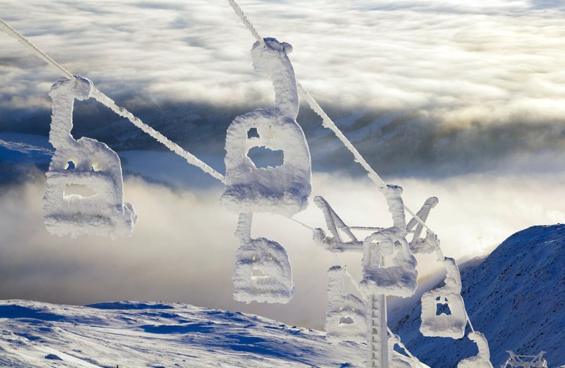 Ice-coated chairlift towers rise above the clouds on Åreskutan mountain