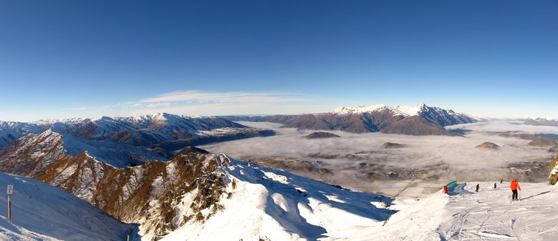 View over the Coronet Peak ski fields toward Queenstown with cloud filling the valley