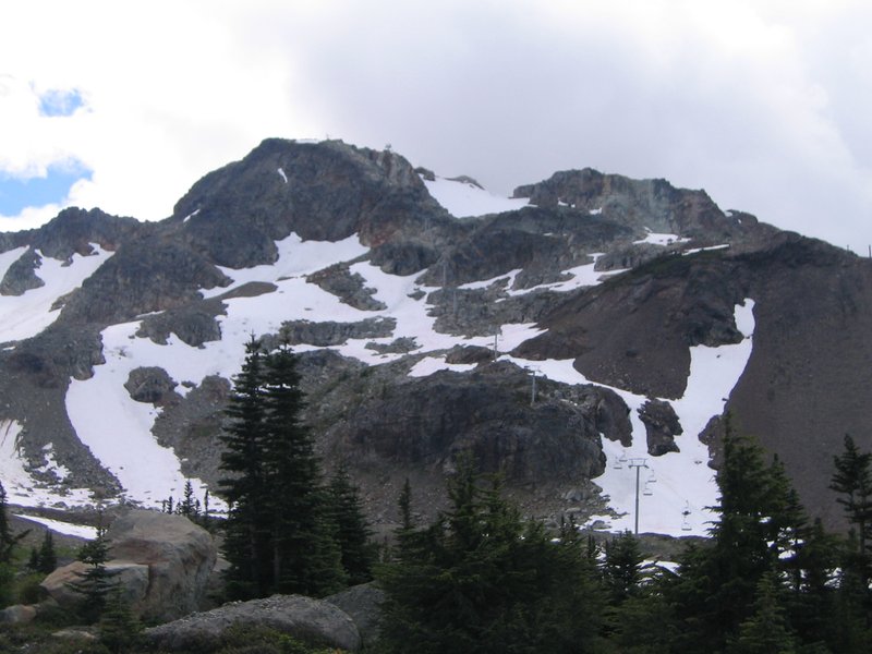 Whistler Mountain's snow-streaked upper slopes with a chairlift line