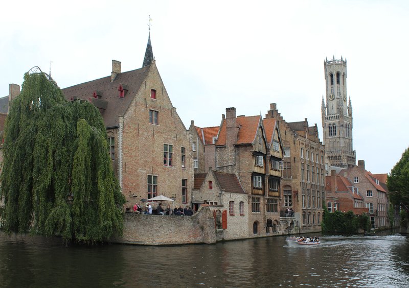 Bruges canal with the Belfry tower reflected in calm water