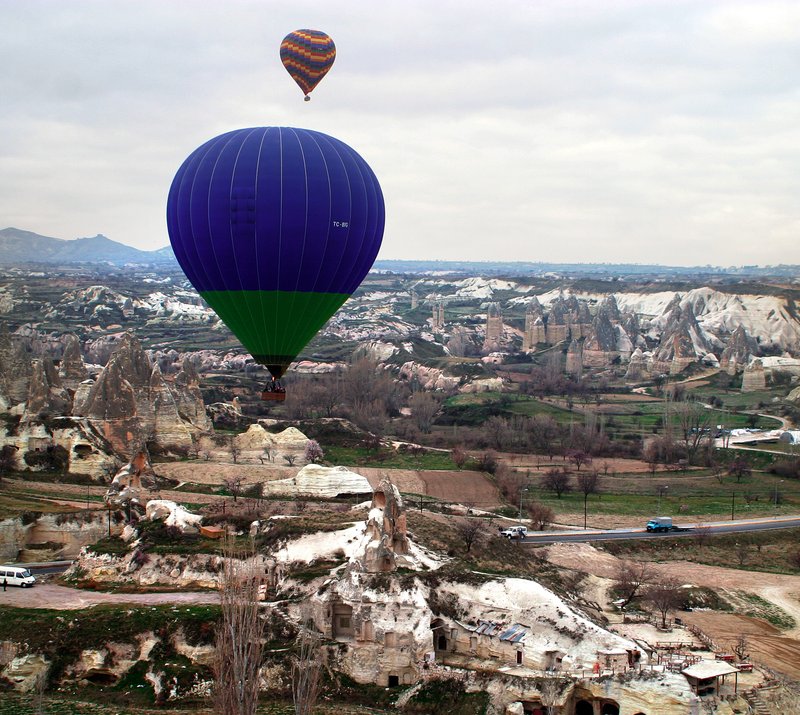 Hot air balloons floating over Cappadocia's fairy-chimney rock formations at dawn