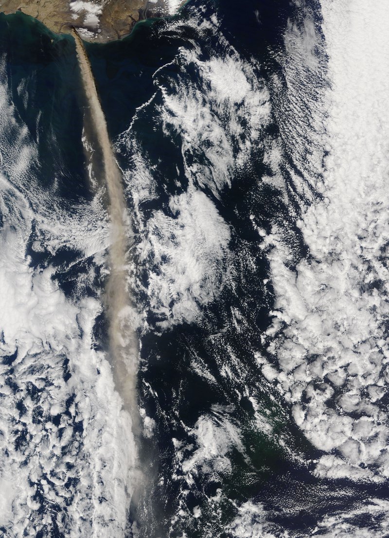 Eyjafjallajökull's eruption column rising above Iceland's snowfields